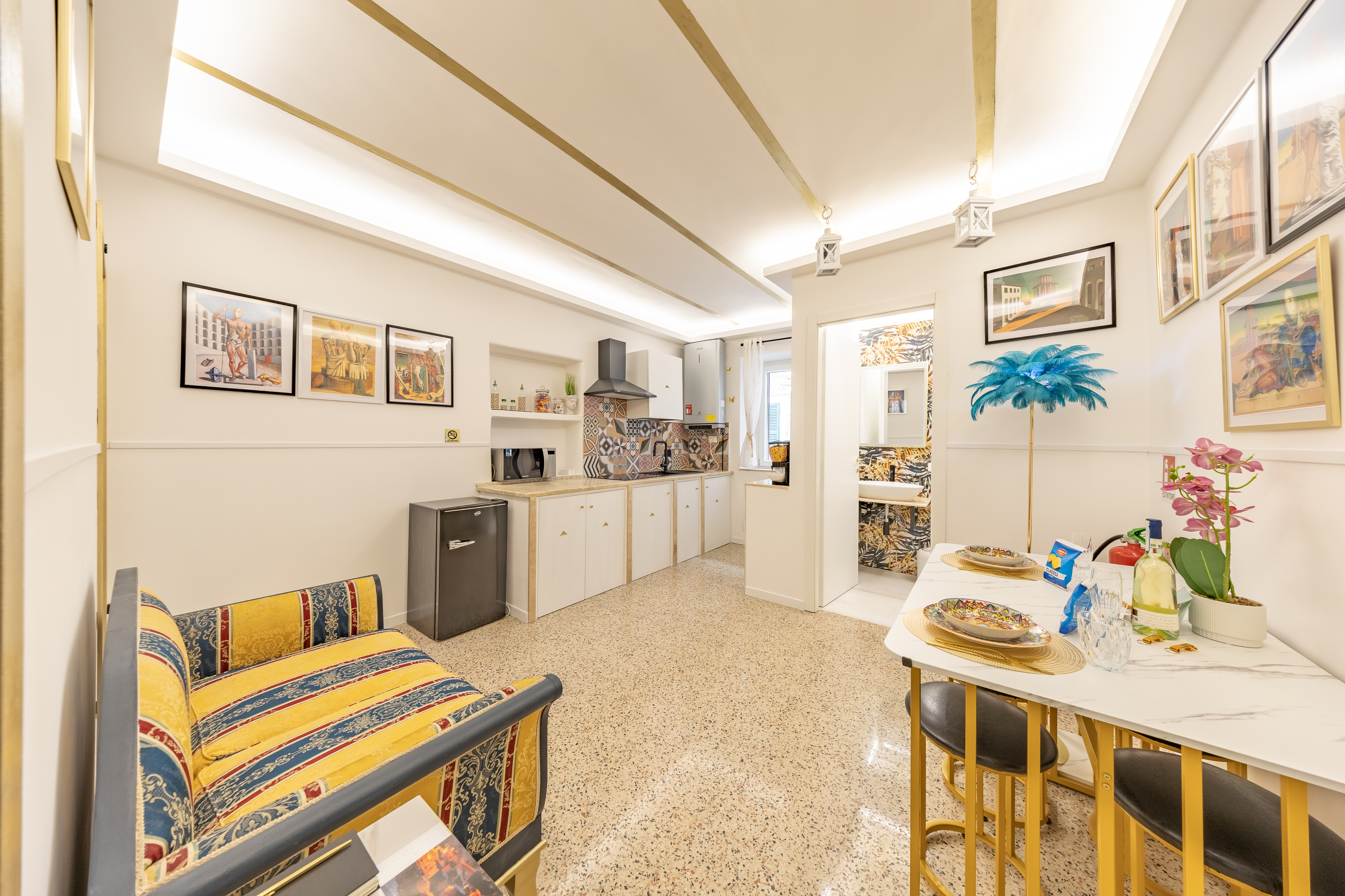 Soggiorno open space con cucina e caratteristiche volte in gesso dorate